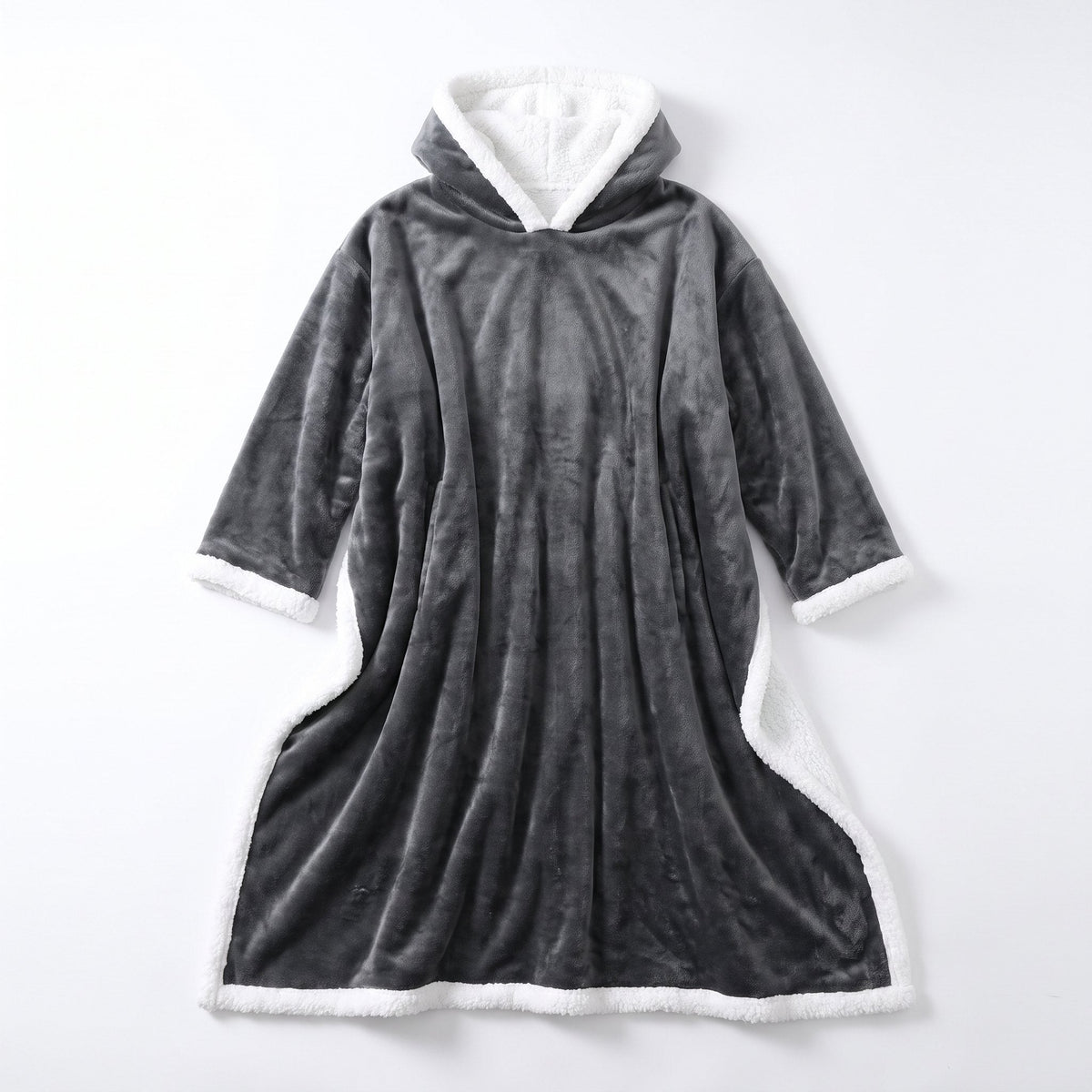 Sitting on the sofa in the grey Wearable Heated Blanket, hood and sherpa lining visible.